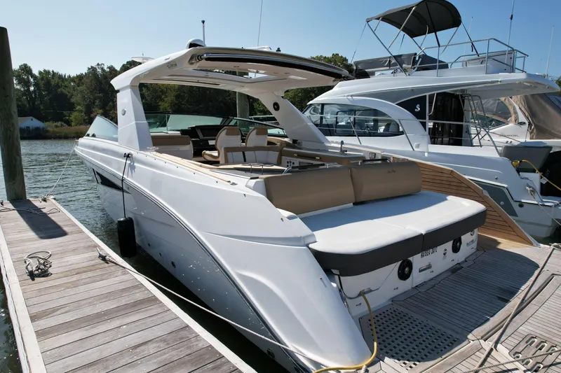 Slide: The Image of 2019 Sea Ray SLX 400 boat docked in a marina under clear blue skies. - 2