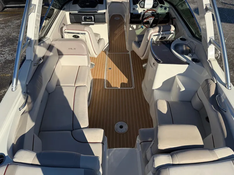 Slide: The Image of 2005 Sea Ray 270 SLX boat interior with beige seating and wood flooring. - 2