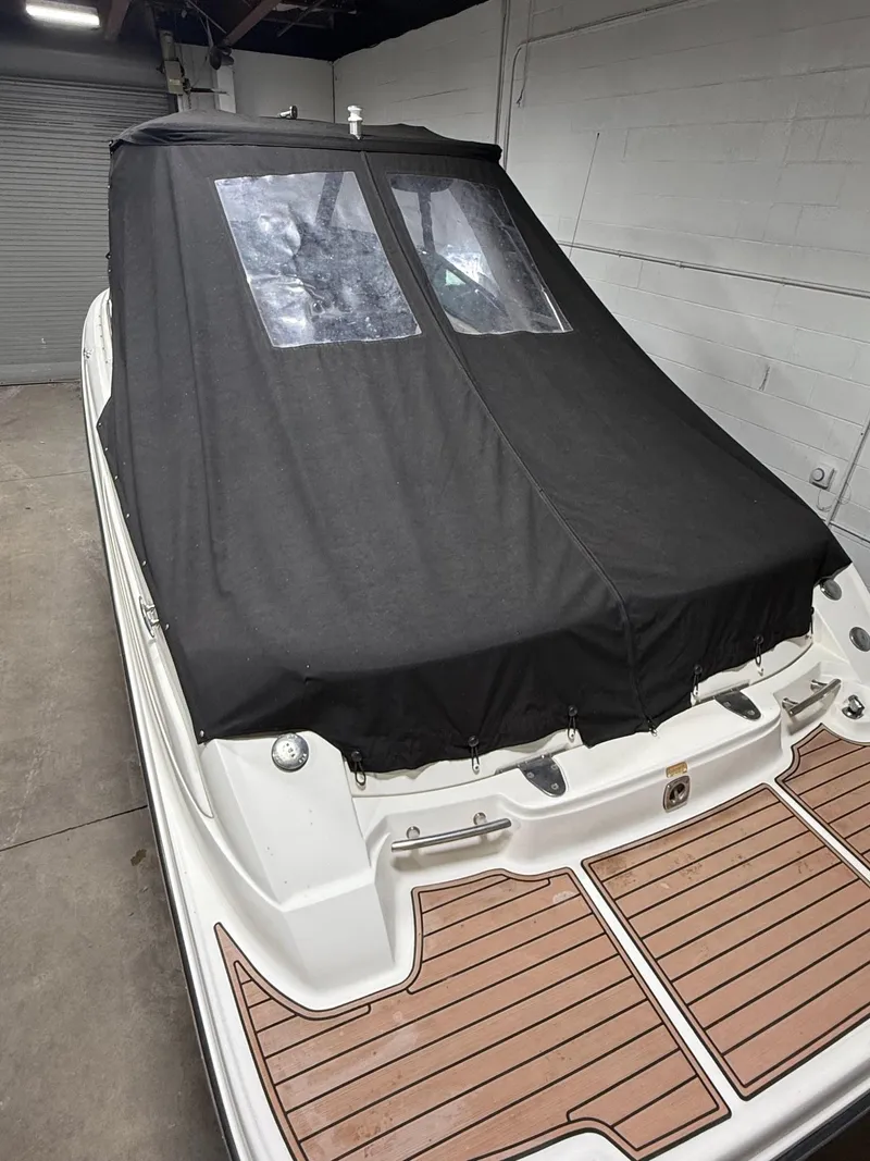 Slide: The Image of 2005 Sea Ray 270 SLX boat with black cover and wooden deck in a garage. - 20