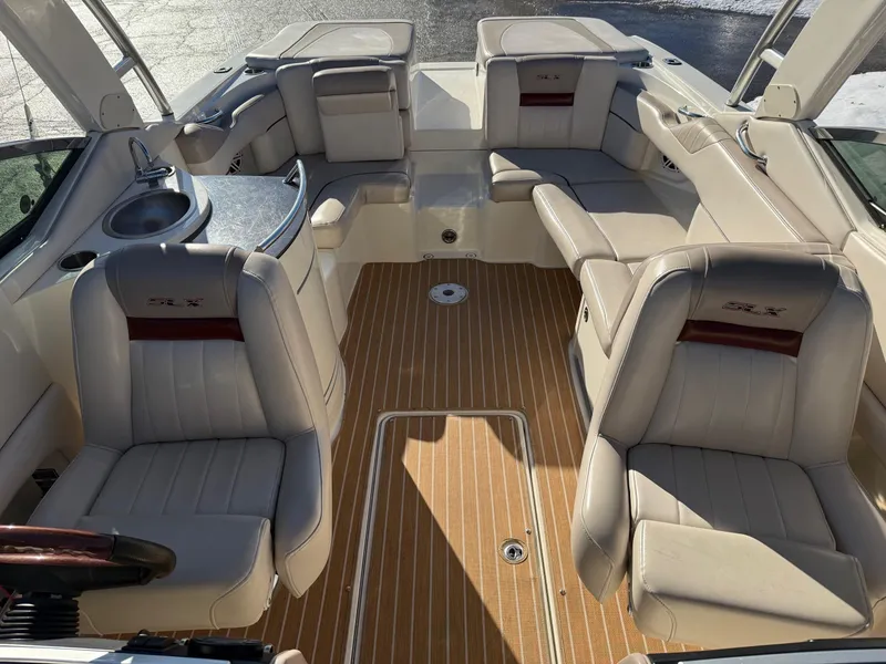 Slide: The Image of 2005 Sea Ray 270 SLX boat interior with beige seating and wood-style flooring. - 3