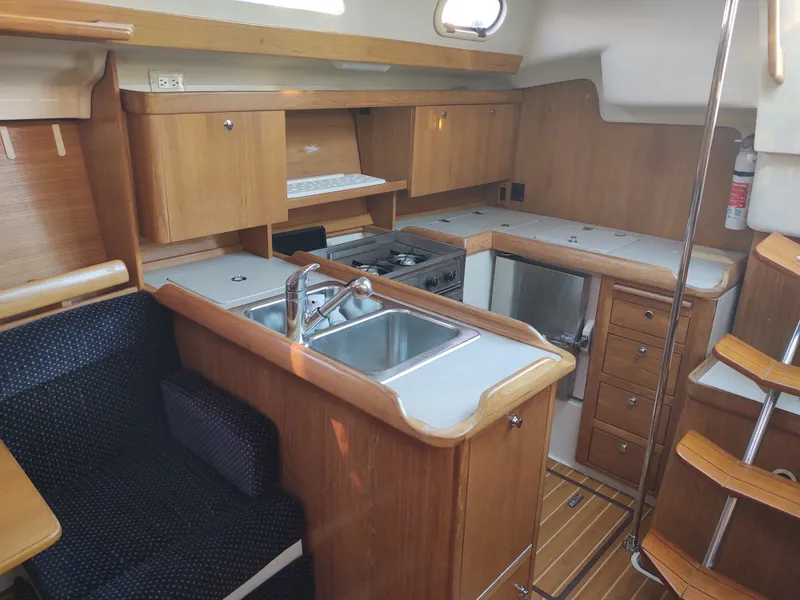 Slide: The Image of Interior of 2006 Catalina 350 MK II sailboat with kitchen and seating area. - 31