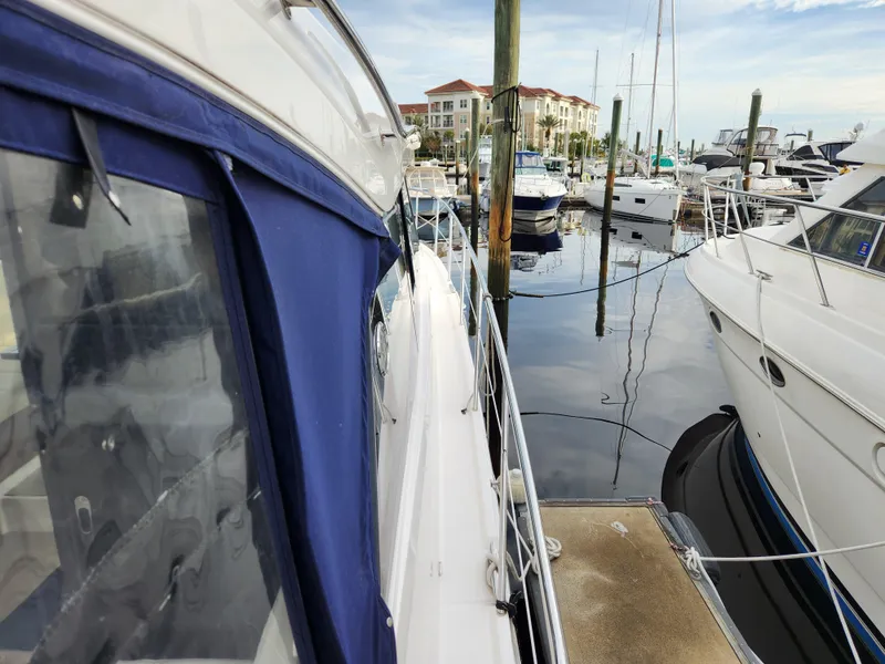 Slide: The Image of 2022 Regal 38 Grande Coupe docked at marina with other boats. - 10