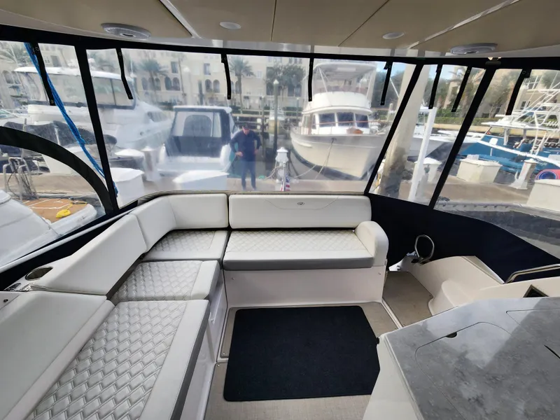 Slide: The Image of 2022 Regal 38 Grande Coupe interior with luxurious seating and marina view. - 13
