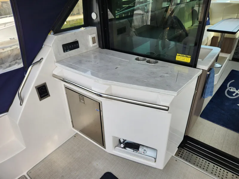 Slide: The Image of 2022 Regal 38 Grande Coupe yacht interior with sleek kitchenette and modern design. - 16