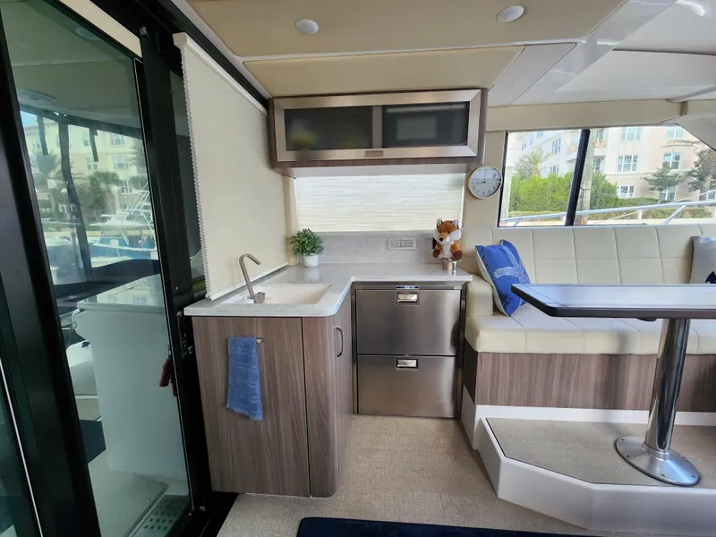 Slide: The Image of Interior of 2022 Regal 38 Grande Coupe yacht with modern kitchen and seating area. - 26