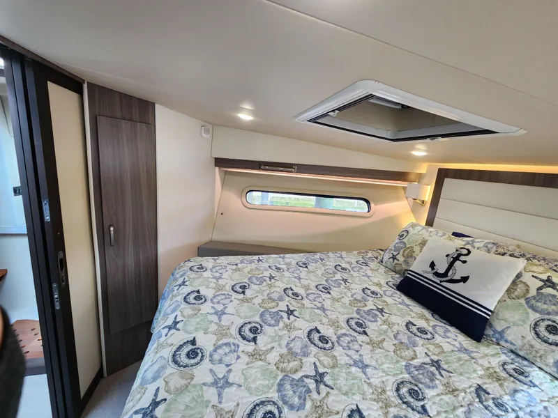 Slide: The Image of Interior of 2022 Regal 38 Grande Coupe bedroom with nautical-themed bedding. - 29