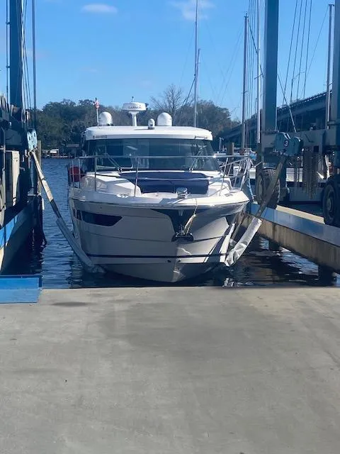 Slide: The Image of 2022 Regal 38 Grande Coupe docked at marina under clear sky. - 45
