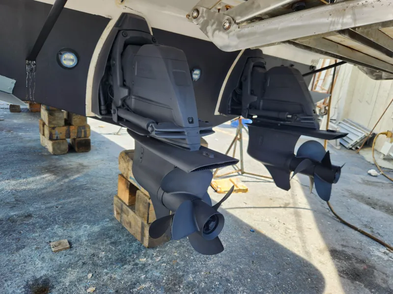 Slide: The Image of 2022 Regal 38 Grande Coupe boat propellers on dry dock, showcasing dual outboard motors. - 47