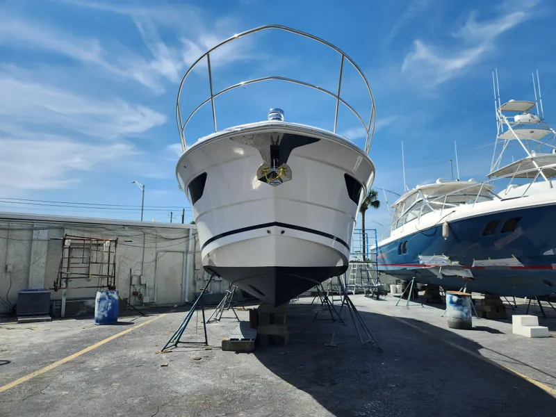 Slide: The Image of 2022 Regal 38 Grande Coupe yacht on dry dock under clear blue sky. - 49