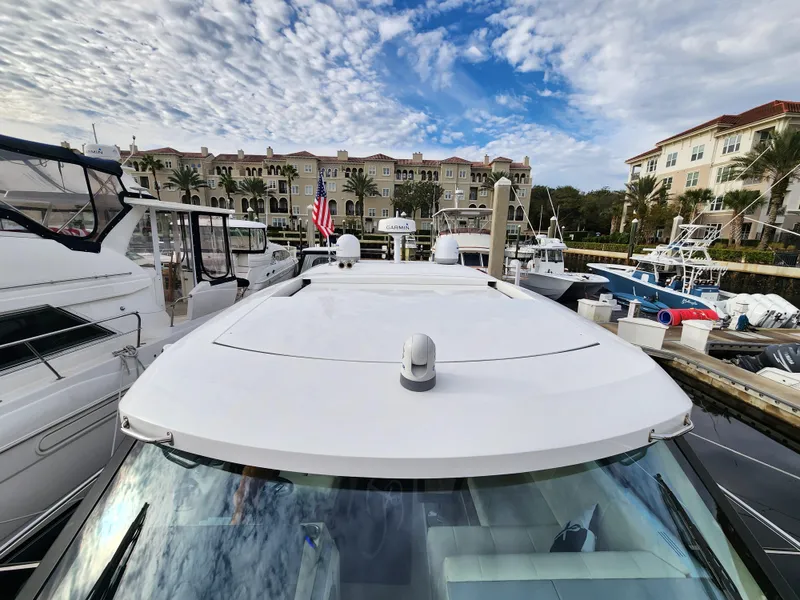 Slide: The Image of 2022 Regal 38 Grande Coupe docked at marina with luxury buildings in background. - 7