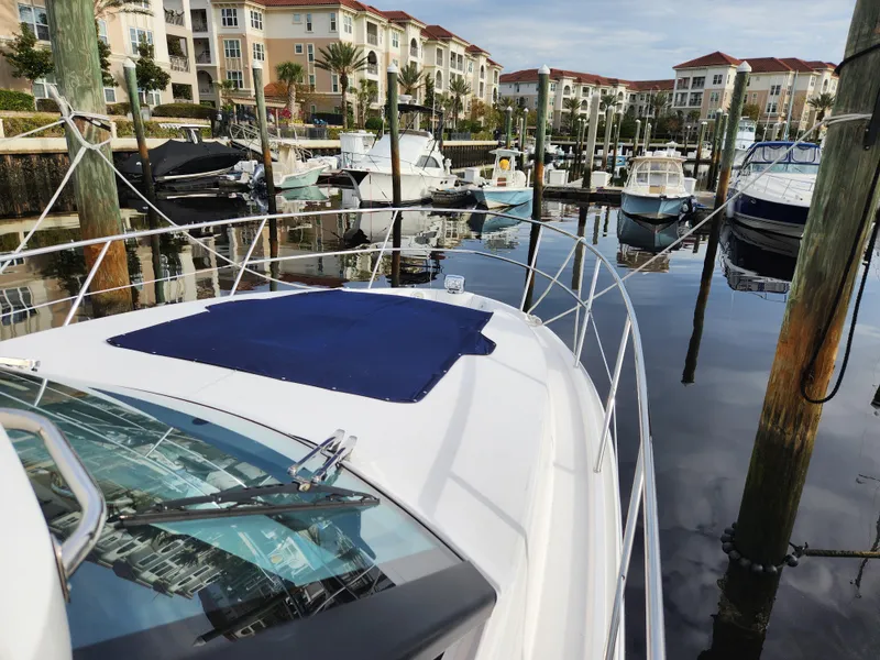 Slide: The Image of 2022 Regal 38 Grande Coupe docked in a marina with luxury apartments. - 8