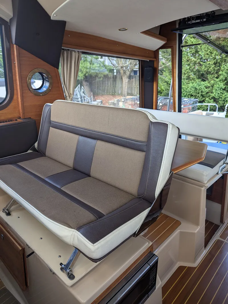 Slide: The Image of 2017 Ranger Tugs R-298 interior with cushioned seating and wooden flooring. - 4
