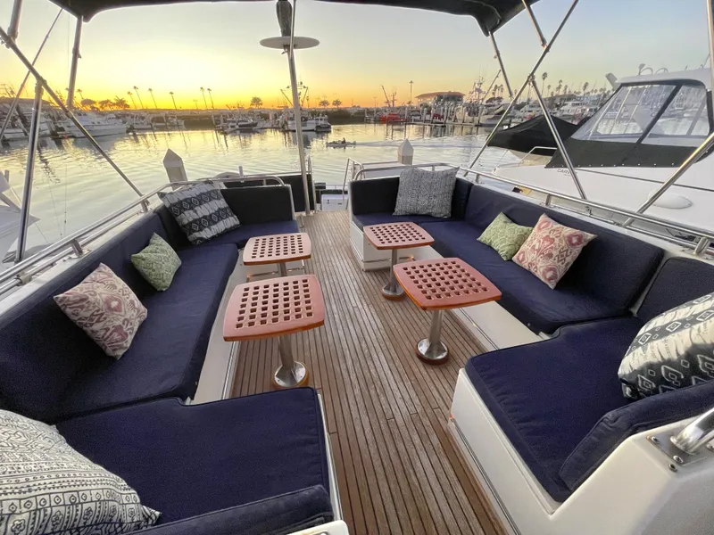 Slide: The Image of Spacious deck of 1995 Grand Banks 49 Motoryacht at sunset, featuring comfortable seating and tables. - 15