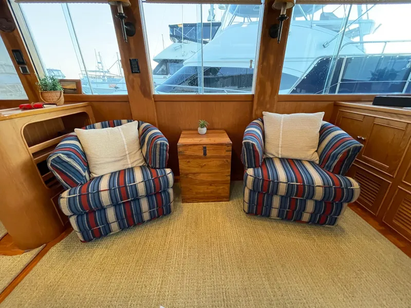 Slide: The Image of Cozy seating area in 1995 Grand Banks 49 Motoryacht with striped armchairs and wooden accents. - 22