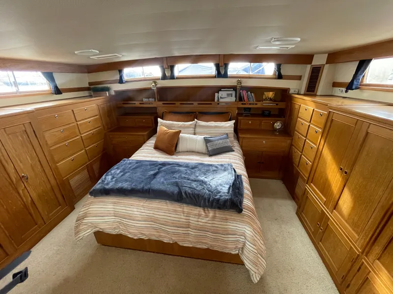 Slide: The Image of Luxurious 1995 Grand Banks 49 Motoryacht bedroom with wood cabinetry and cozy bedding. - 24