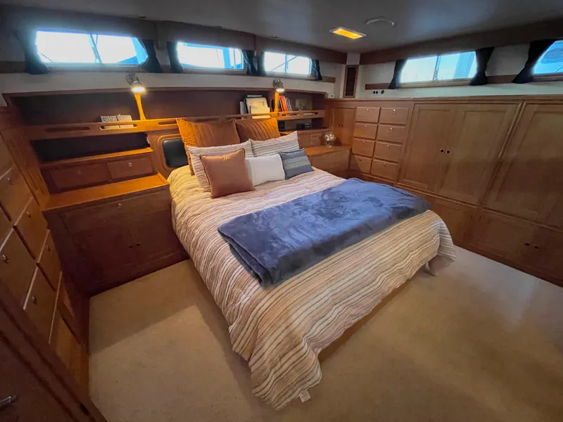 Slide: The Image of Luxurious bedroom in 1995 Grand Banks 49 Motoryacht with wood cabinetry and cozy bedding. - 25