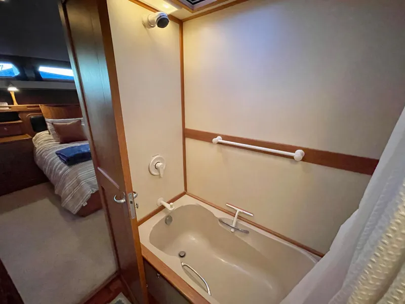 Slide: The Image of Luxurious bathroom in 1995 Grand Banks 49 Motoryacht with bathtub and cozy bedroom view. - 29