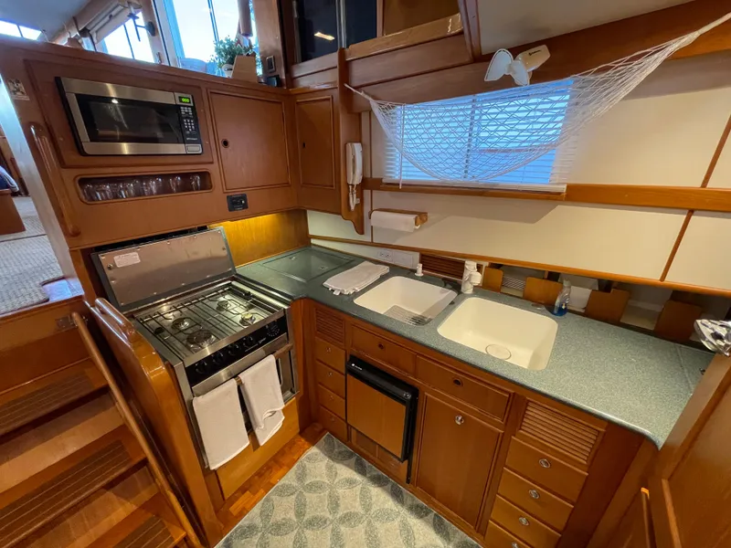 Slide: The Image of 1995 Grand Banks 49 Motoryacht kitchen with stove, microwave, and dual sinks. - 31