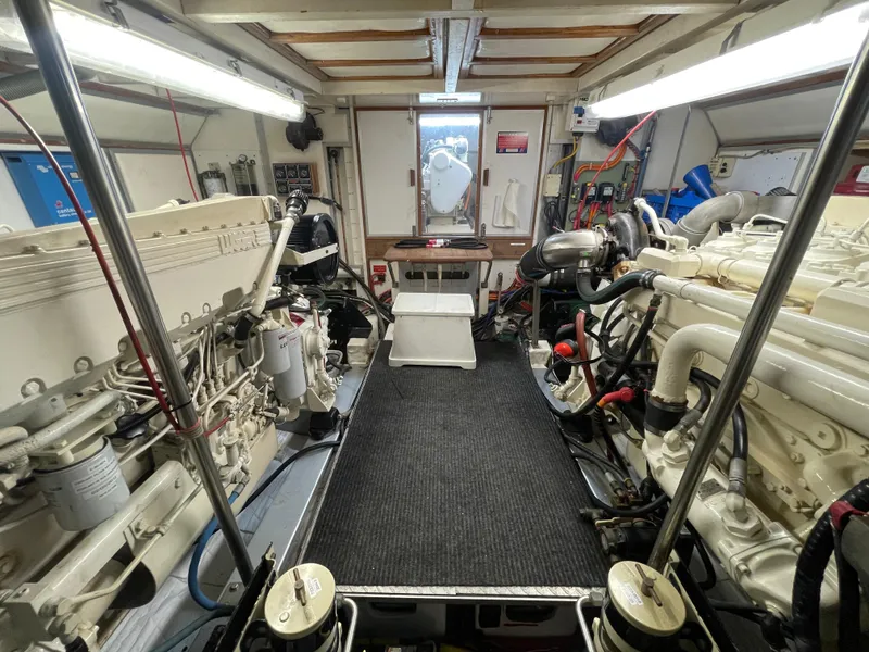 Slide: The Image of Engine room of 1995 Grand Banks 49 Motoryacht, featuring dual engines and control systems. - 35