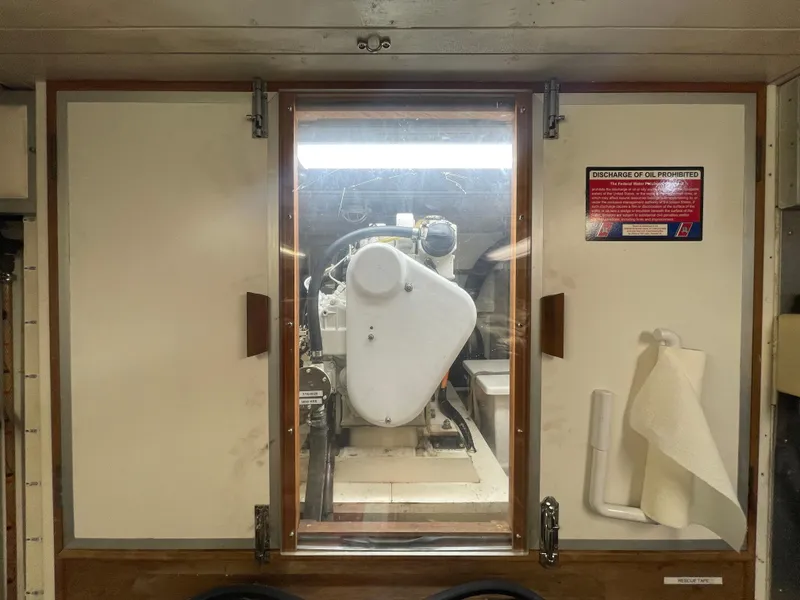 Slide: The Image of Engine room of 1995 Grand Banks 49 Motoryacht with visible machinery and safety instructions. - 40
