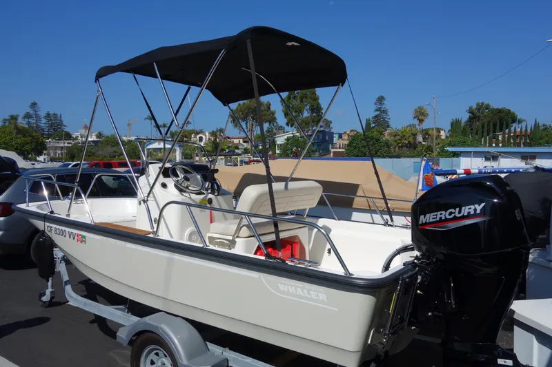 Slide: The Image of 2023 Boston Whaler 150 Montauk boat with Mercury engine on trailer. - 0