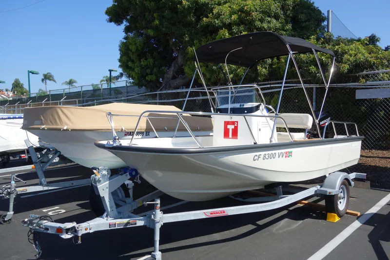 Slide: The Image of 2023 Boston Whaler 150 Montauk boat on trailer, parked outdoors. - 1