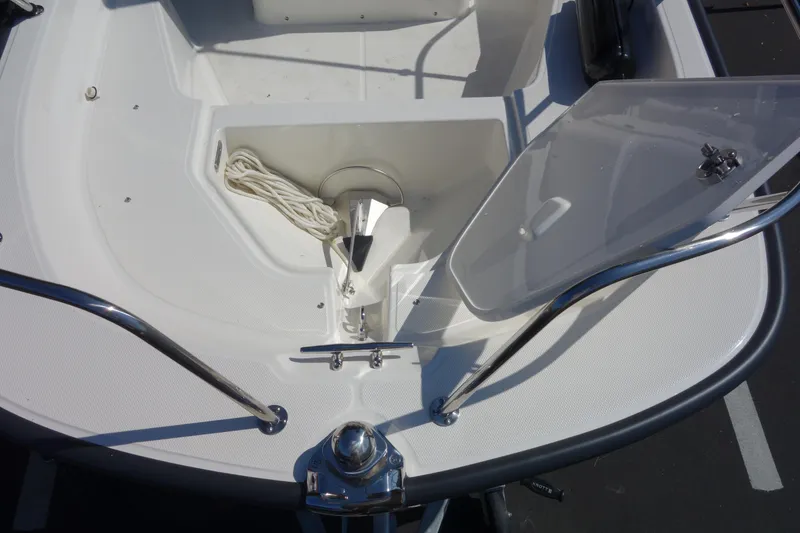 Slide: The Image of 2023 Boston Whaler 150 Montauk anchor storage compartment with open hatch. - 11