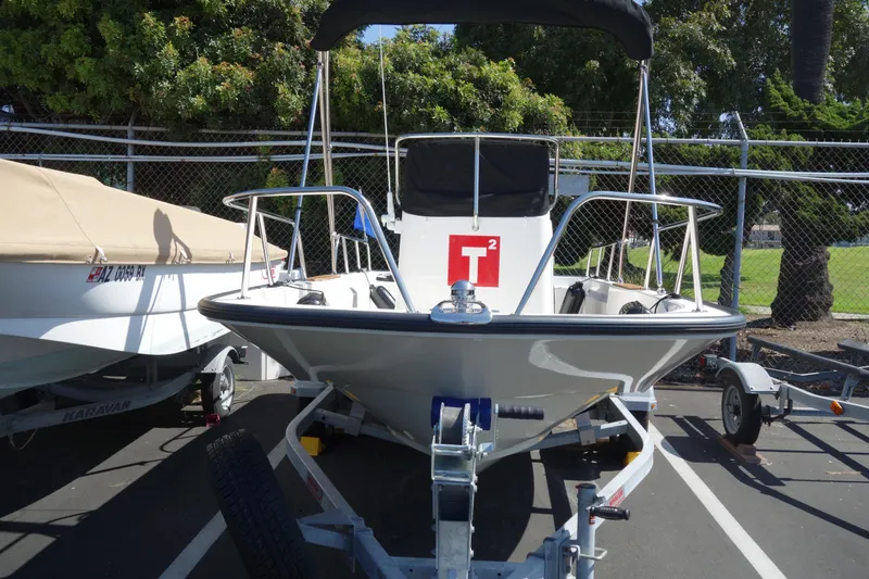Slide: The Image of 2023 Boston Whaler 150 Montauk boat on trailer in parking lot. - 16