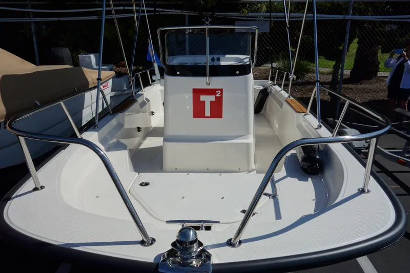 Slide: The Image of 2023 Boston Whaler 150 Montauk boat with T² logo, docked in sunlight. - 7
