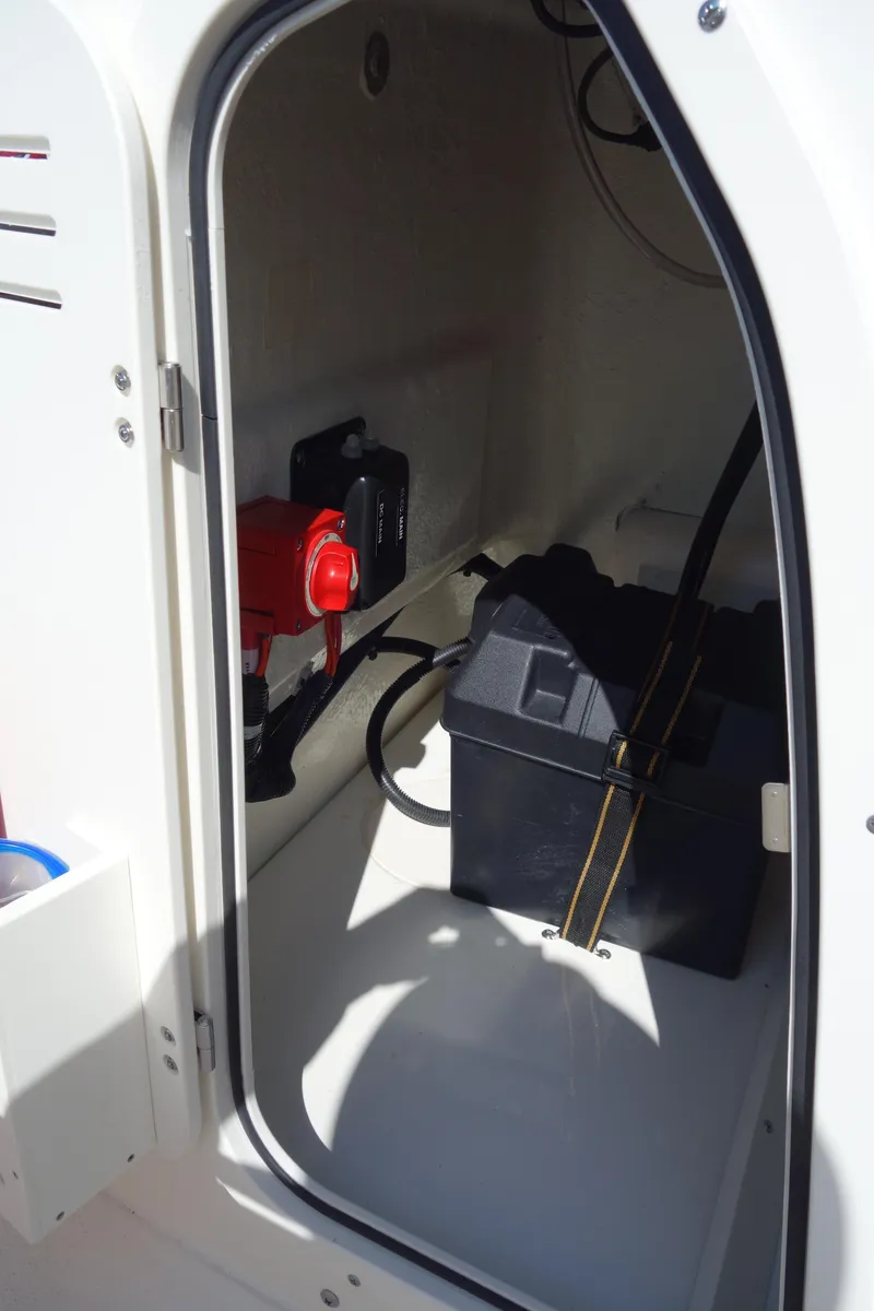 Slide: The Image of 2023 Boston Whaler 150 Montauk boat storage compartment with battery and wiring. - 9