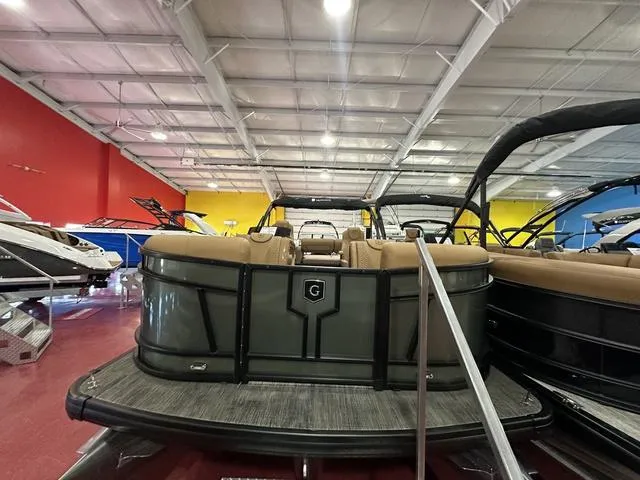 Slide: The Image of 2025 Godfrey Pontoons Monaco 235 DFL in showroom, featuring sleek design and center tube package. - 3