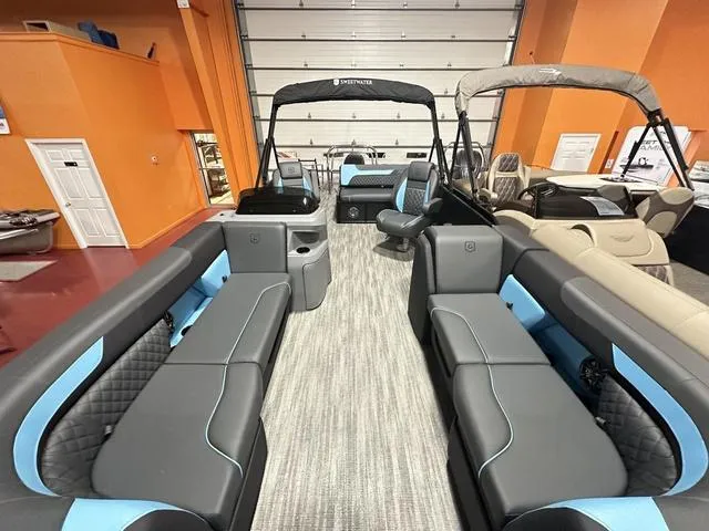Slide: The Image of 2025 Godfrey Pontoons Sweetwater 2286 SFL interior with modern seating and helm in a garage. - 22