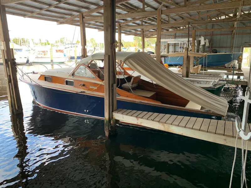 Slide: The Image of 1960 Prowler Semi-enclosed boat docked in a covered marina. - 12