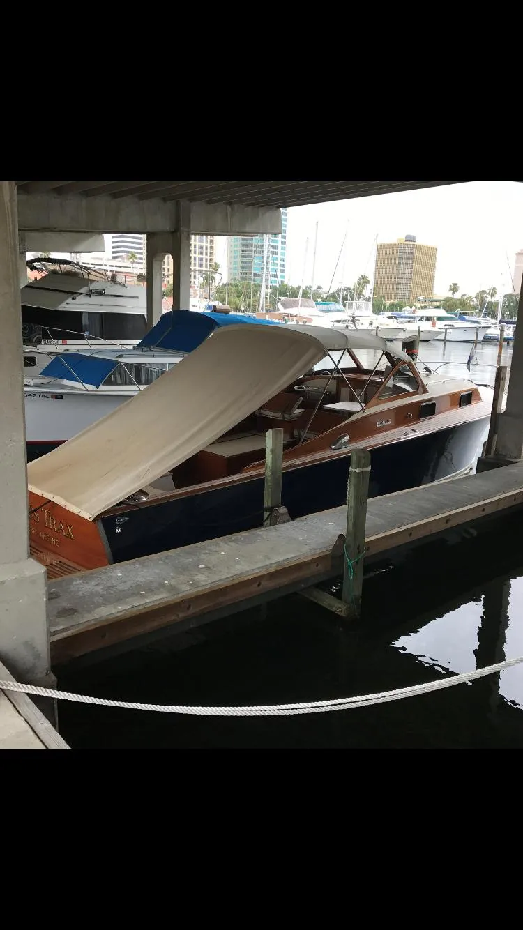 Slide: The Image of 1960 Prowler Semi-enclosed boat docked in a marina under a shelter. - 13