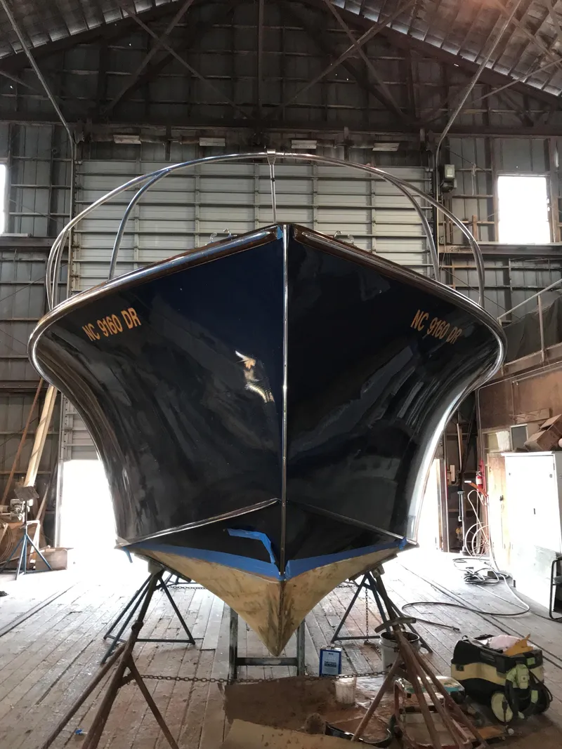 Slide: The Image of 1960 Prowler Semi-enclosed boat in a wooden boathouse, viewed from the front. - 16