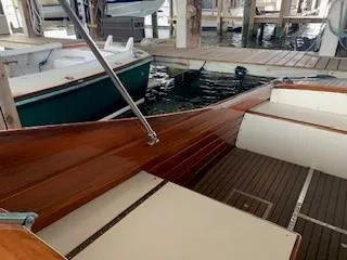 Slide: The Image of 1960 Prowler Semi-enclosed boat interior with wooden finish, docked in a marina. - 2