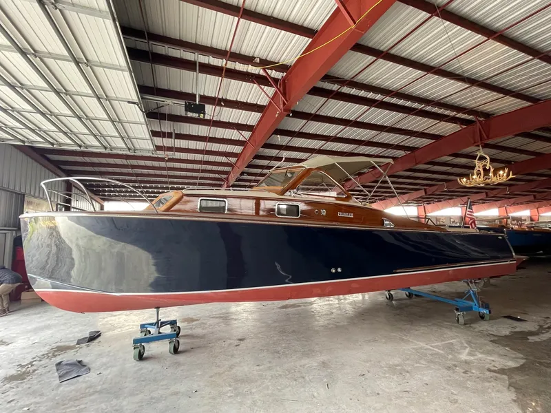 Slide: The Image of 1960 Prowler Semi-enclosed boat in storage, featuring sleek design and classic wooden finish. - 24