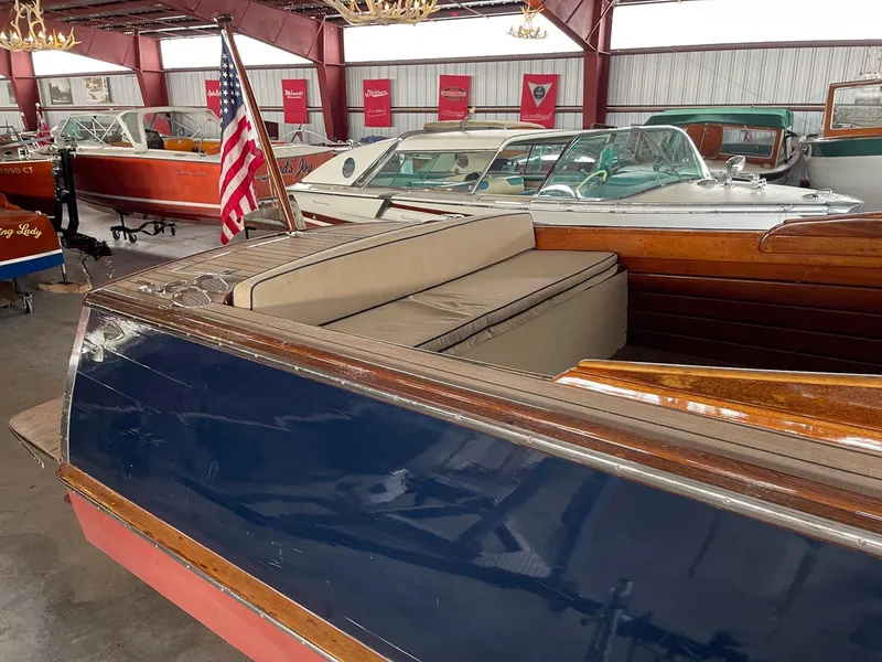 Slide: The Image of 1960 Prowler Semi-enclosed boat with American flag in a vintage boat showroom. - 27