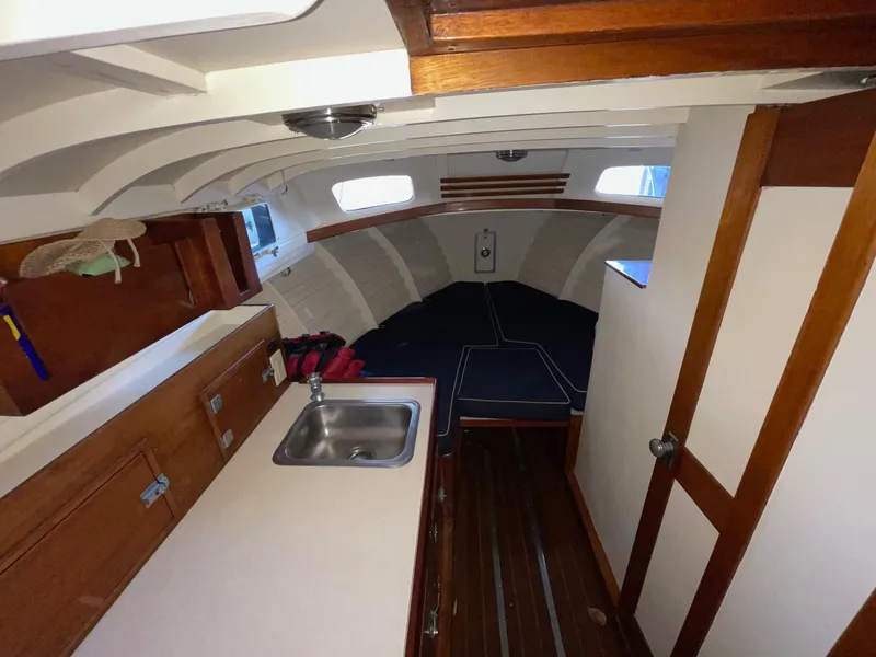 Slide: The Image of 1960 Prowler Semi-enclosed boat interior with wooden cabinetry and compact kitchen area. - 29