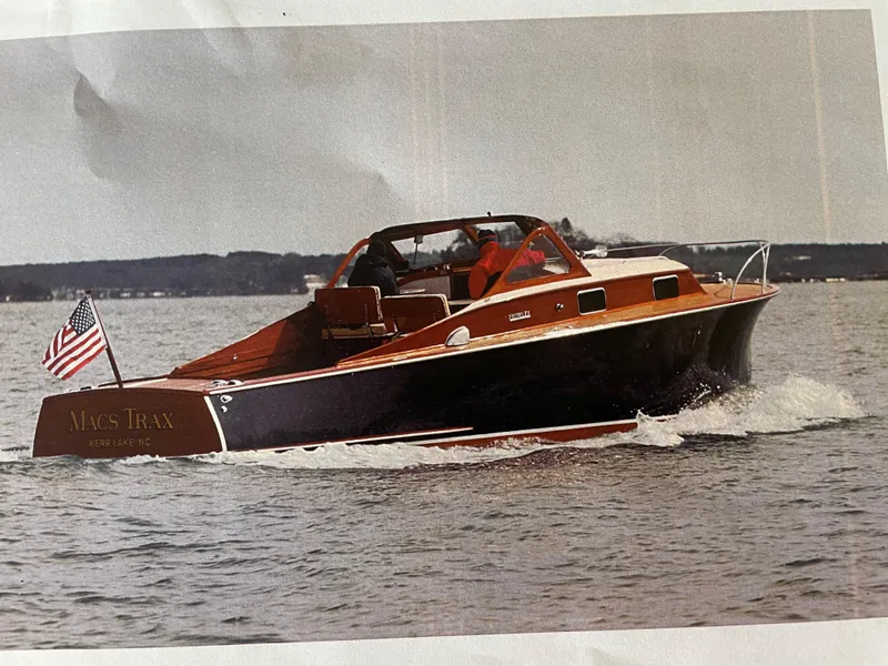Slide: The Image of 1960 Prowler Semi-enclosed boat cruising on water with American flag. - 3