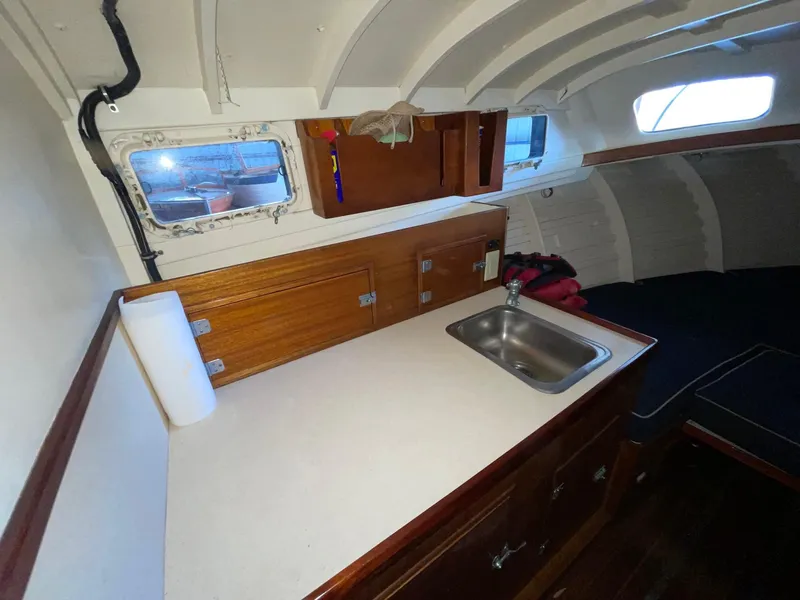 Slide: The Image of 1960 Prowler Semi-enclosed boat interior with wooden cabinetry and small sink. - 30