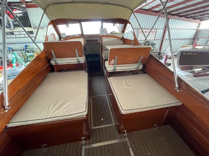 Slide: The Image of 1960 Prowler Semi-enclosed boat interior with cushioned seating and wooden finish. - 32