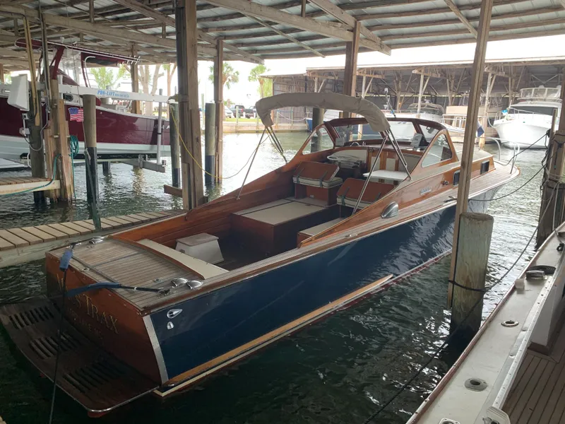 Slide: The Image of 1960 Prowler Semi-enclosed boat docked in a marina, featuring classic wooden design. - 7