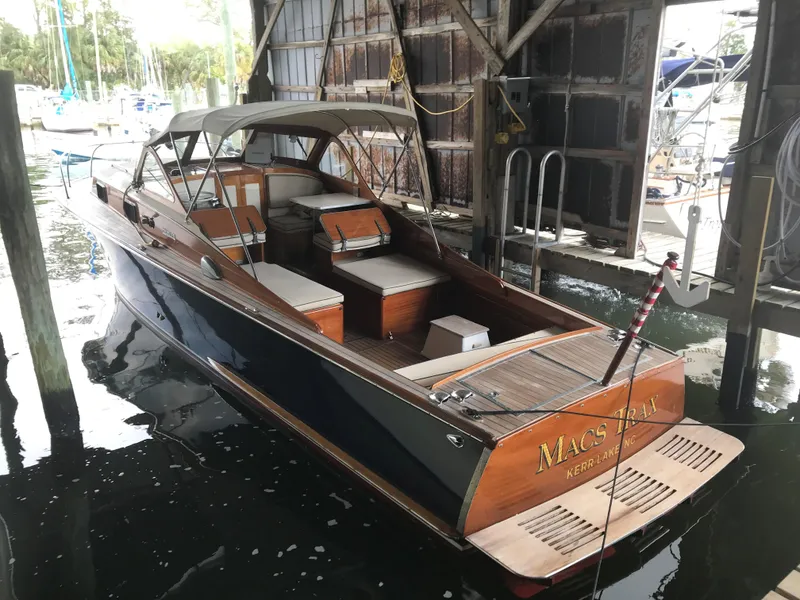 Slide: The Image of 1960 Prowler Semi-enclosed boat docked in a marina, featuring wooden accents and canopy. - 9