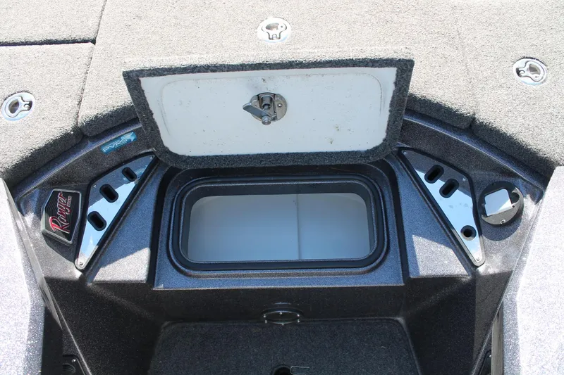 Slide: The Image of 2020 Ranger Z521L boat storage compartment with open lid and carpeted interior. - 12
