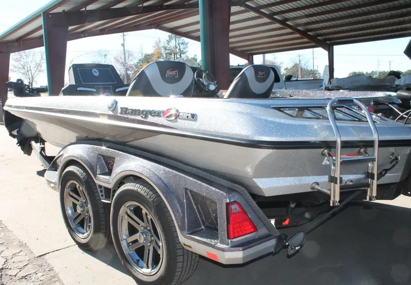Slide: The Image of 2020 Ranger Z521L boat with dual seats and trailer under a metal canopy. - 27