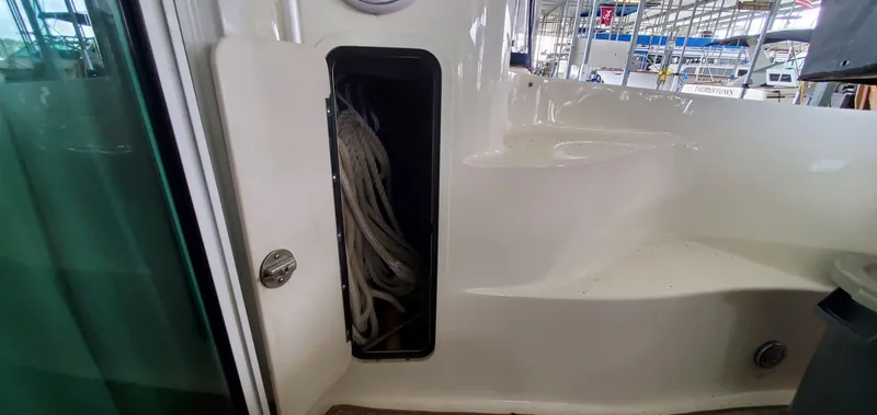 Slide: The Image of 2001 Sea Ray 400 Sedan Bridge interior with storage compartment and ropes. - 33