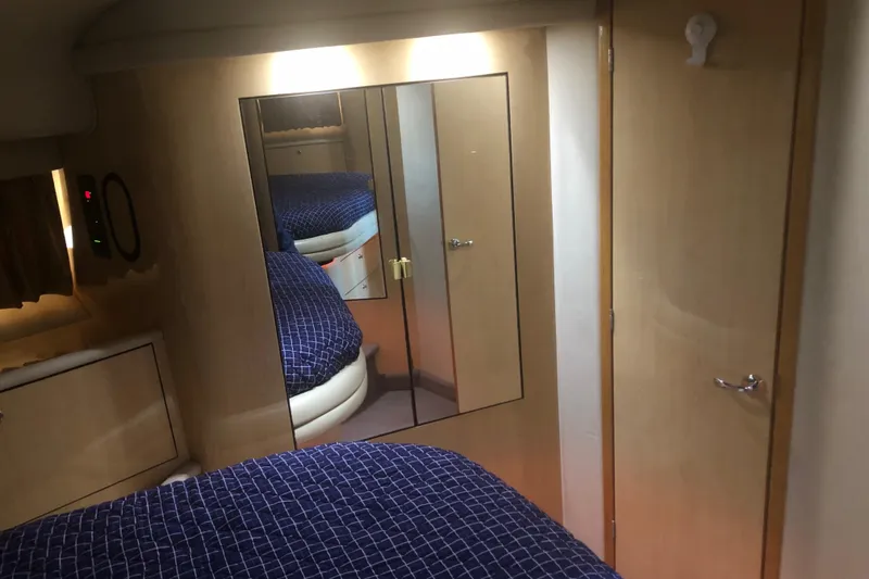 Slide: The Image of Interior of 2001 Sea Ray 400 Sedan Bridge with blue bedding and mirrored closet. - 38