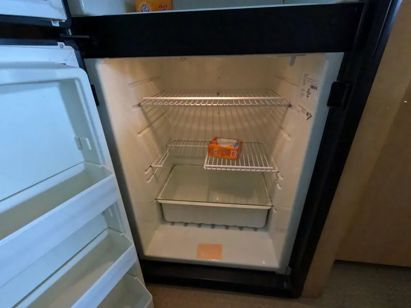 Slide: The Image of Open fridge on 2001 Sea Ray 400 Sedan Bridge, containing a box of baking soda. - 54