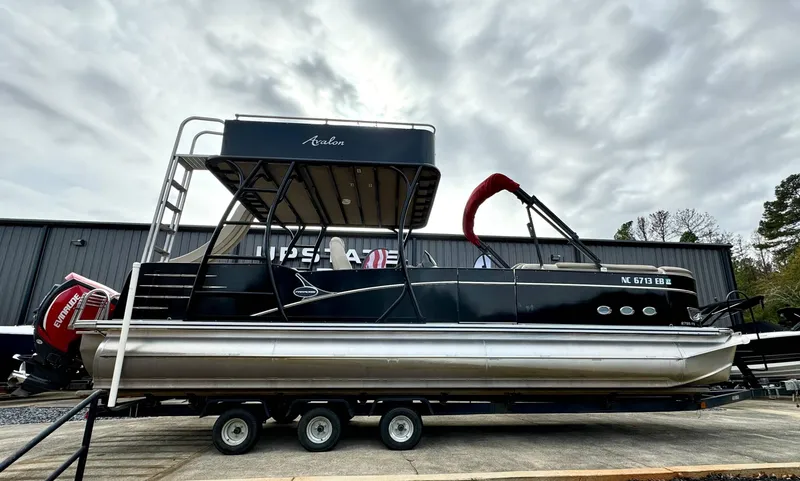 Slide: The Image of 2015 Avalon 2785 Paradise pontoon boat on trailer, overcast sky background. - 1